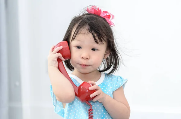 Asian girl using red vintage phone at home. — Stock Photo, Image