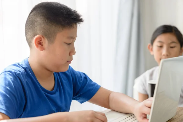 Gelukkig Aziatische jongen en meisje met behulp van Tablet PC thuis. — Stockfoto