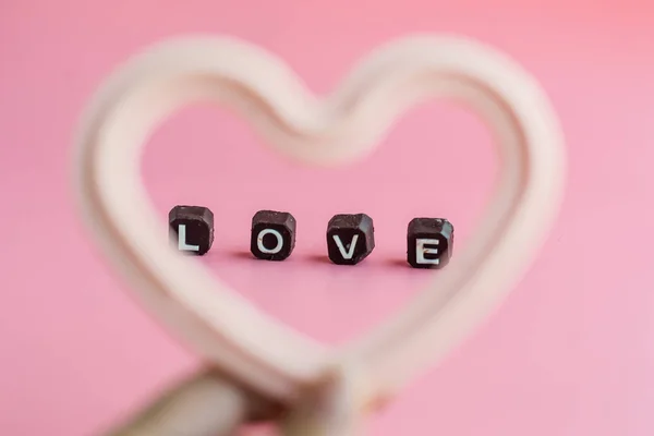 Mano sosteniendo chocolate blanco en forma de corazón con el mensaje de amor en —  Fotos de Stock
