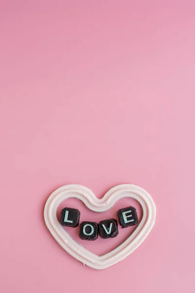 White chocolate in heart shape with message love on pink backgro — Stock Photo, Image