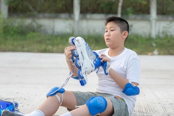Asiatischer Junge trägt Schutzset vor Skate-Outdoor. — Stockfoto