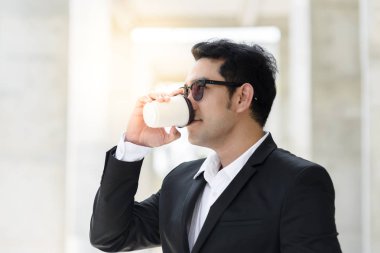 Kahve içme ve boğa ayakta modern iş adamı