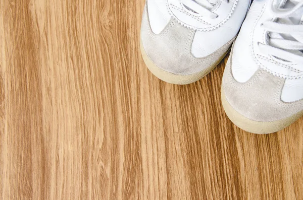 Zapatos deportivos sucios sobre fondo de madera, vista superior . — Foto de Stock
