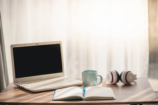 Кофейная кружка с ноутбуком белый ноутбук и наушники на столе nea — стоковое фото