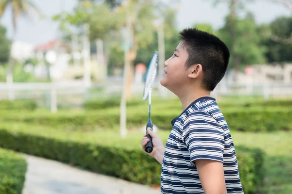 Joyeux Asiang garçon jouer au badminton en plein air . — Photo