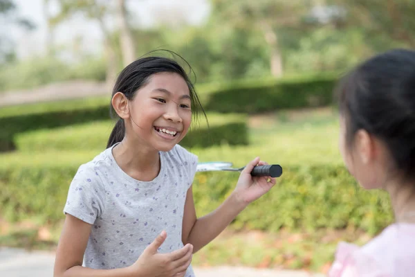 Szczęśliwa dziewczyna azjatyckich gospodarstwa badmintona i rozmowy z przyjacielem. — Zdjęcie stockowe