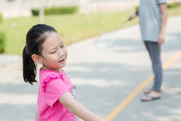 快乐亚洲女孩学习羽毛球在公园户外, 在 — 图库照片