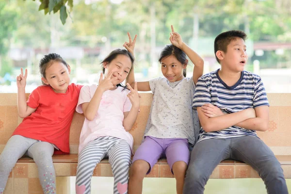 Happy children sitting together in the park outdoor. — Stock Photo, Image