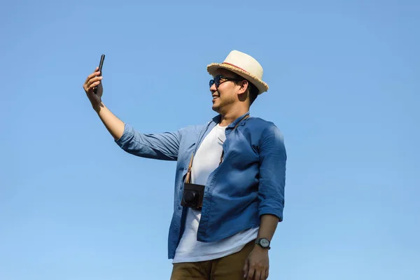 Turista asiático feliz usando selfie smartphone-se com azul sk — Fotografia de Stock
