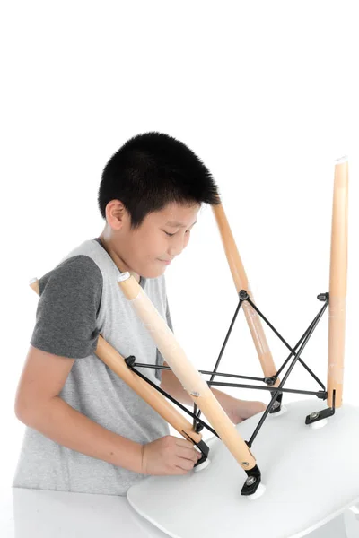 Asian boy repair leg chair on white backgorund. — Stock Photo, Image