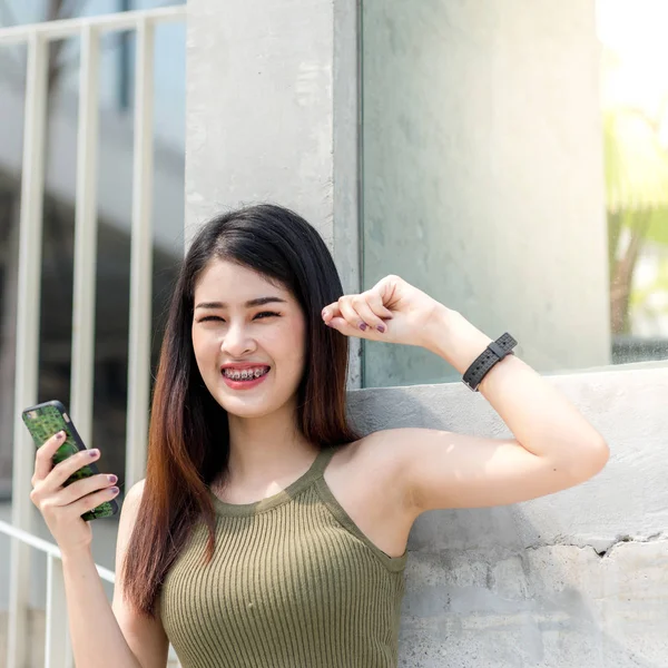 Gyönyörű ázsiai nő használ smartphone, épület-háttér, — Stock Fotó