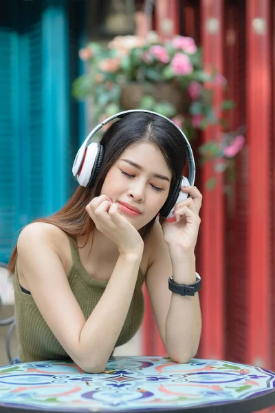 Heureuse belle femme utilisant casque écoutant de la musique en plein air, l — Photo