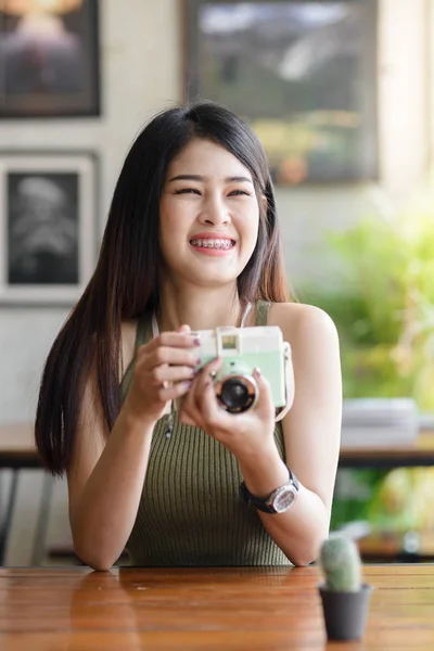 Gelukkig Aziatische vrouw nemen foto cactus door vintage camera in café, — Stockfoto