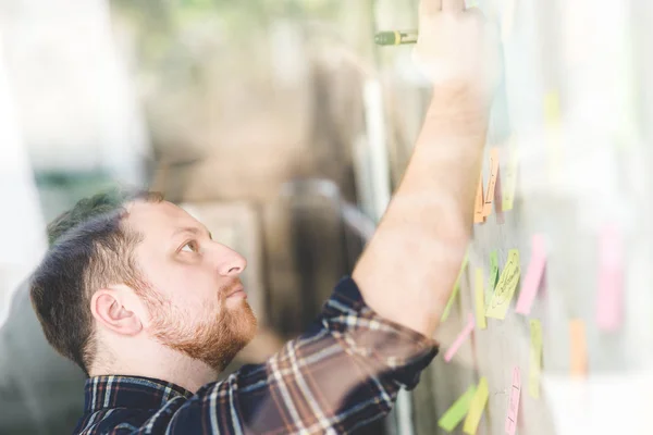 Uomo d'affari creativo che scrive appunti su carta in ufficio — Foto Stock