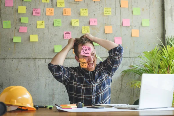 Stressad man med meddelande på klisterlappar över sitt ansikte i offic — Stockfoto