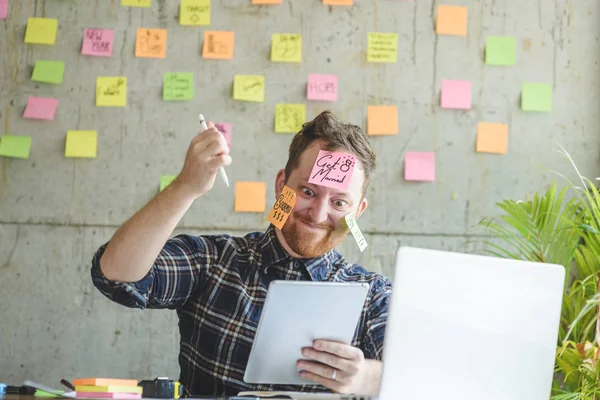 Man met bericht op plaknotities benadrukt over zijn gezicht in kantoor — Stockfoto