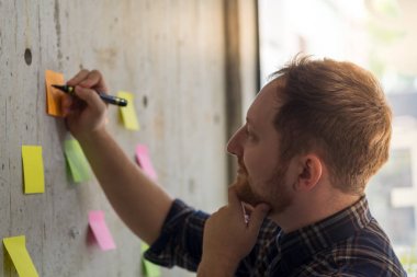 Ofiste kağıda notlar yazma yaratıcı iş adamı