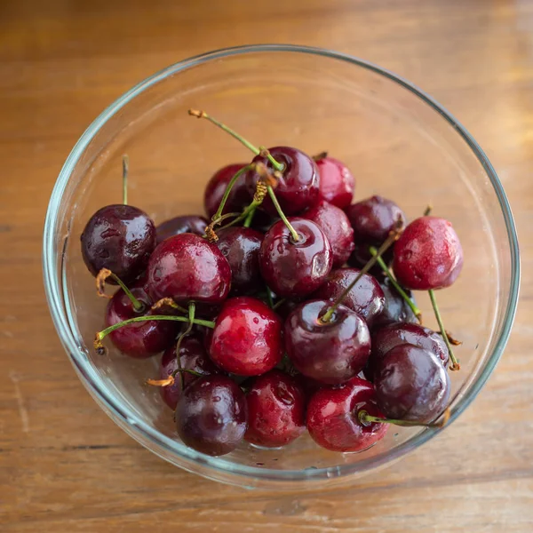 Amarene fresche appena raccolte in ciotola sul tavolo di legno . — Foto Stock