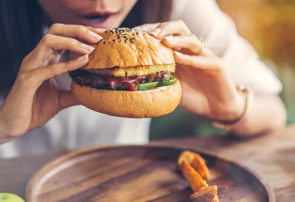 Mujer comiendo hamburguesa de carne en el restaurante . — Foto de Stock