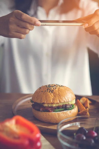 Mulher mãos tirando foto carne hambúrguer com smartphone, estilo de vida — Fotografia de Stock