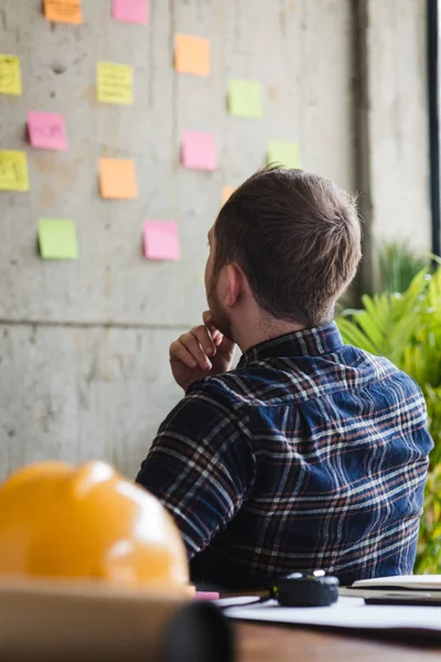 Back of engineer sitting in office and look at colorful sticky m — Stock Photo, Image