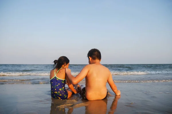 Glada barn som sitter på Hua Hin beach i solig dag. — Stockfoto