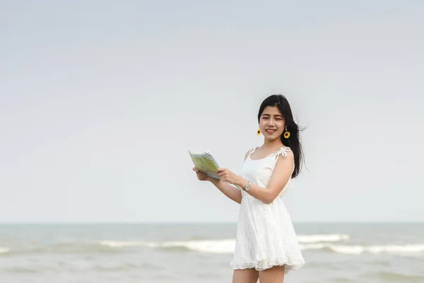 Glückliche Touristin mit Karte am Strand. — Stockfoto