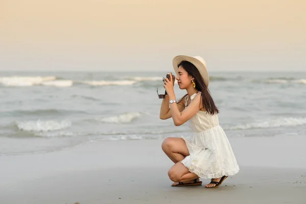 Mujer asiática usando sombrero con vestido blanco tomando fotos en el bea —  Fotos de Stock