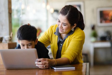 Mutlu Asya anne ve oğlu dizüstü evde kullanma.