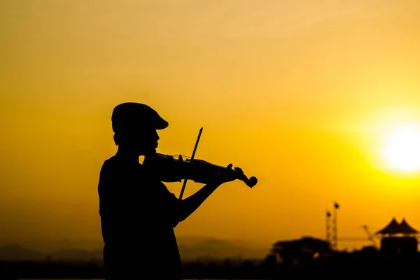 Silhouette Junge spielt Geige mit Sonnenuntergang. — Stockfoto