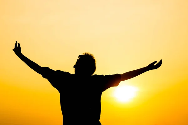 Silhouette boy raising hands with sun set outdoor. — Stock Photo, Image