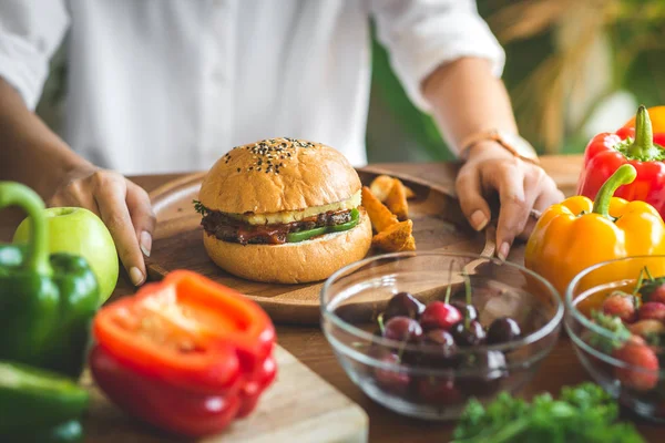 Hambúrguer de carne em placa de madeira com legumes . — Fotografia de Stock