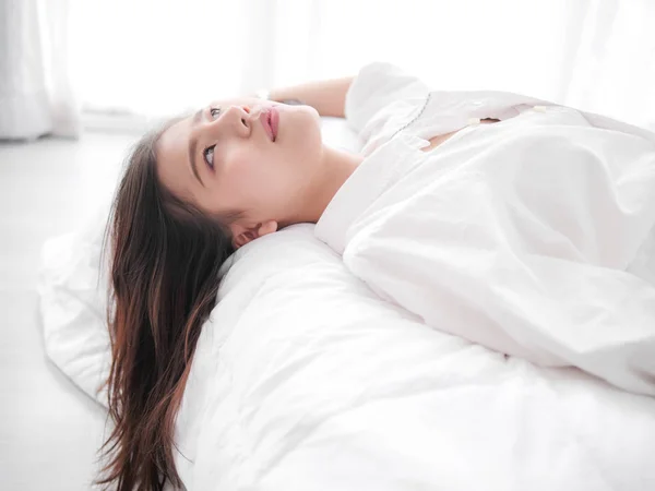 Glad asiatisk kvinna liggande på sängen, stängde upp. — Stockfoto
