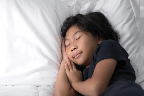Heureux asiatique fille sommeil sur lit avec copie espace . — Photo