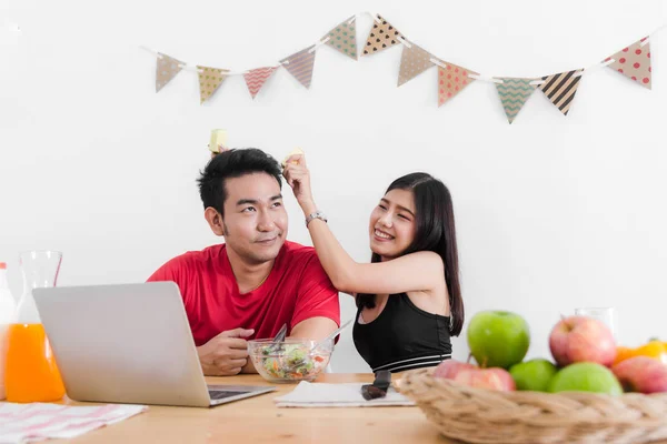 Feliz pareja asiática usando laptop y comiendo ensalada y fruta fresca — Foto de Stock