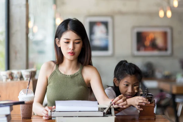 Bella donna asiatica che lavora con la macchina da scrivere e insegnare il suo s — Foto Stock