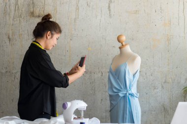 Genç tasarımcısı çalışırken akıllı telefon alarak resim kullanarak