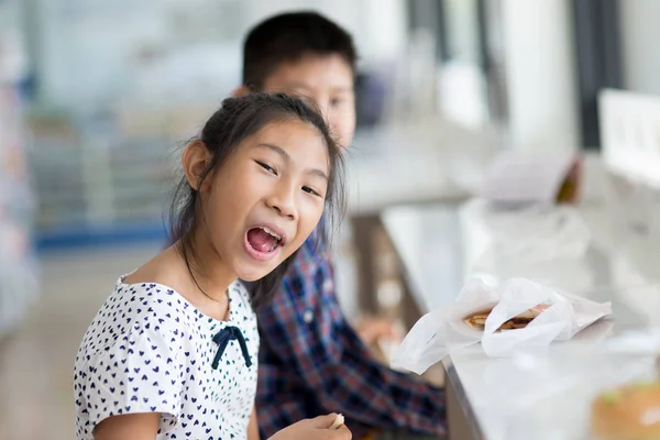 Feliz asiático niños comer algunos bocadillos en moderno conveniencia sto — Foto de Stock