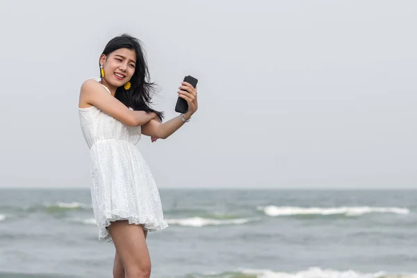 Glückliche asiatische Touristen Selfie sich mit Smartphone am Strand. — Stockfoto