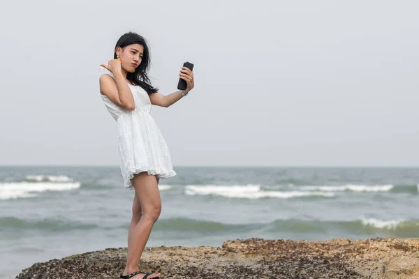 Felice asiatica selfie turistico se stessa con smartphone sulla spiaggia . — Foto Stock