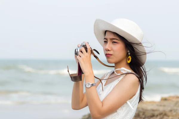 Asiatische touristin taking photo auf die strand. — Stockfoto