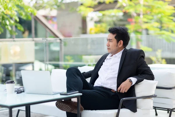 Promyšlené asijský podnikatel posezení v kavárně s městem poza — Stock fotografie