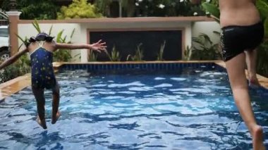 Mutlu kız ve erkek yüzme havuzunda, yavaş atlama. 