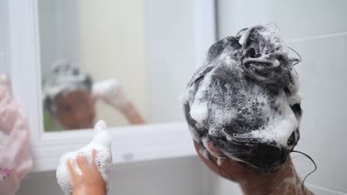 Saçlarını banyoda dans ve sabunla yıkama geri Asyalı kız, yavaş hareket.