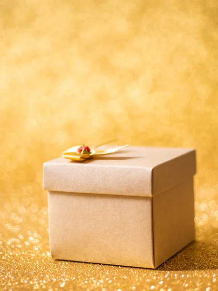 Bruine geschenkdoos op gouden glitter achtergrond. — Stockfoto