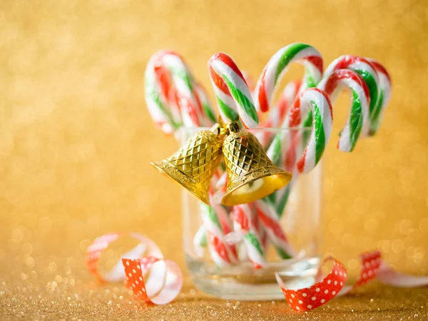 Vánoční cukroví tyčinky na skle se stříbrným pozadí bokeh. — Stock fotografie