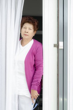 Yaşlı kadın ev giriş kapısı açma