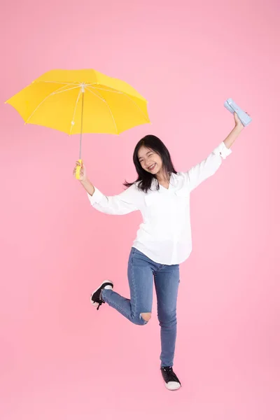 Asiatische Teenager Mädchen mit gelben Regenschirm während der kalten regnerischen da — Stockfoto