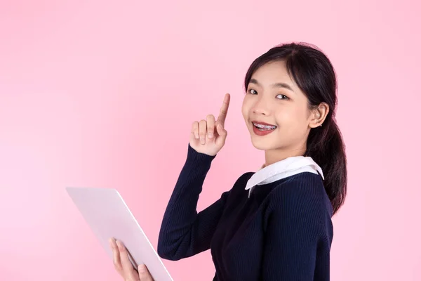 Happy Asian teenager girl using laptop and pointing up for idea — Stock Photo, Image