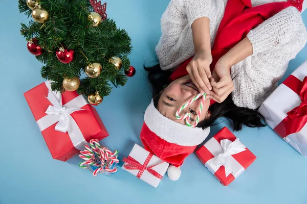 Asiatische Teenager Mädchen trägt Weihnachtsmütze liegend auf dem Boden mit Christus — Stockfoto
